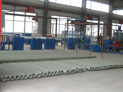 It shows the cable pipe production warehouse and there are many cable pipes on the ground.