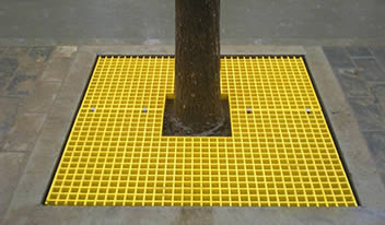 Yellow FRP tree grating for tree protection.